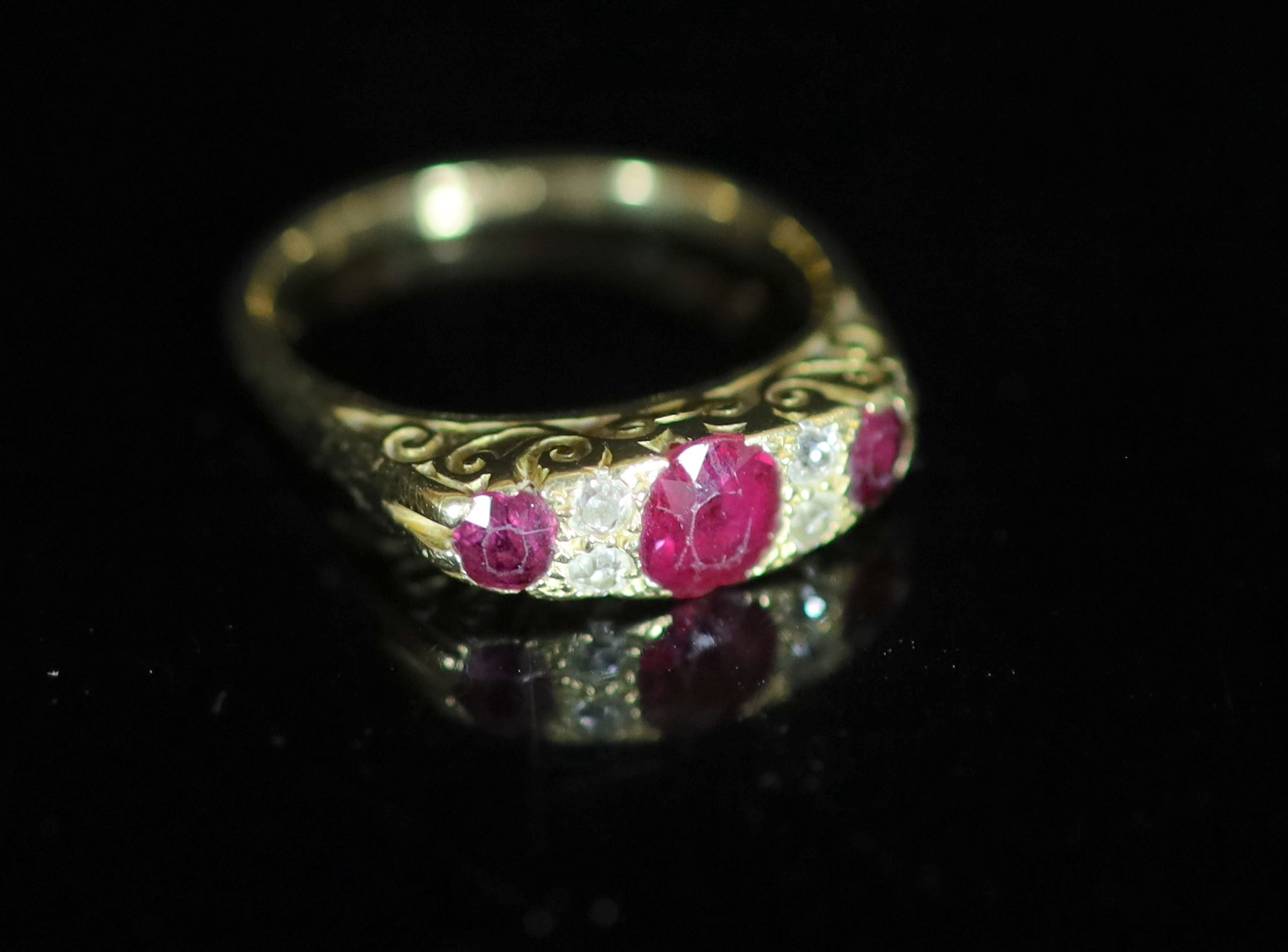 An early 20th century 18ct gold, three stone ruby and four stone diamond chip set half hoop ring